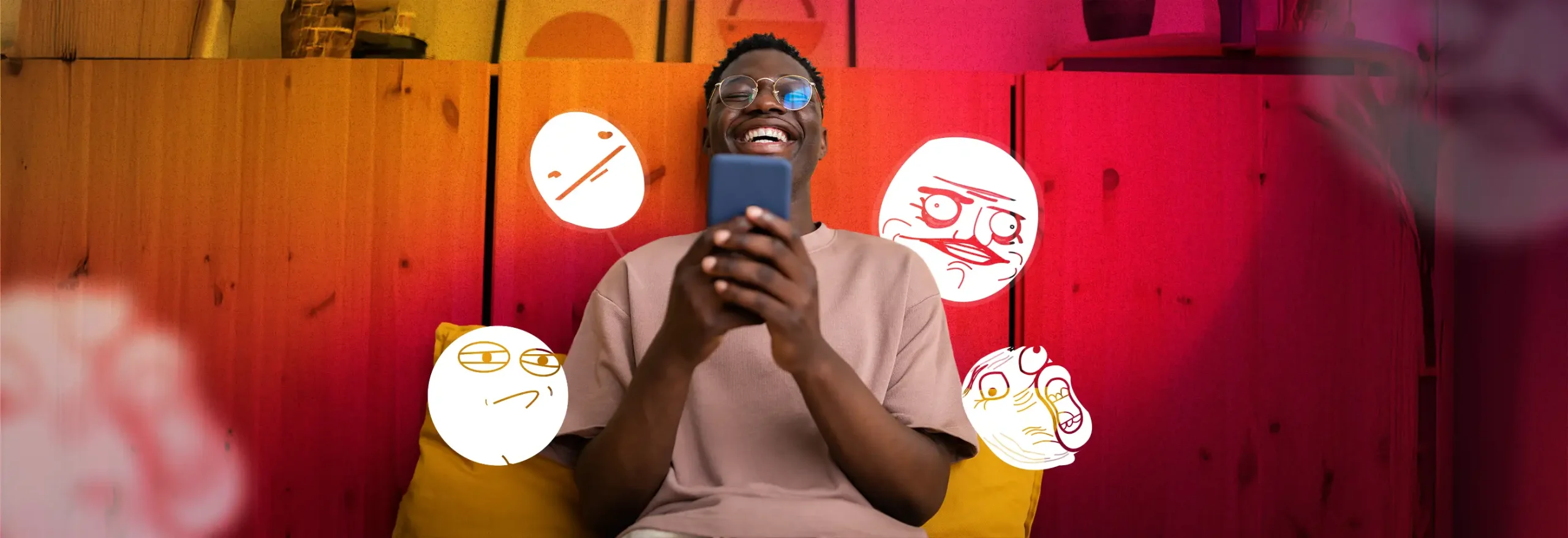 Laughing man holding smartphone with floating hand-drawn meme faces on vibrant orange and pink background
