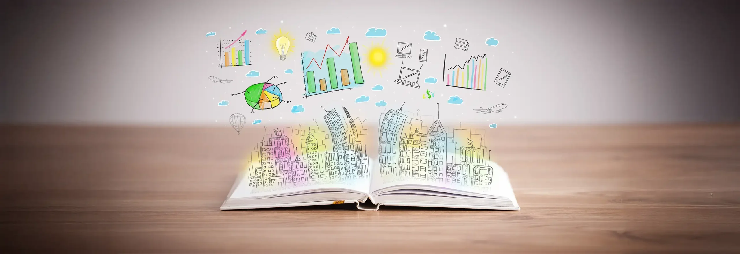 Open book on wooden surface with hand-drawn cityscape and business charts emerging from its pages